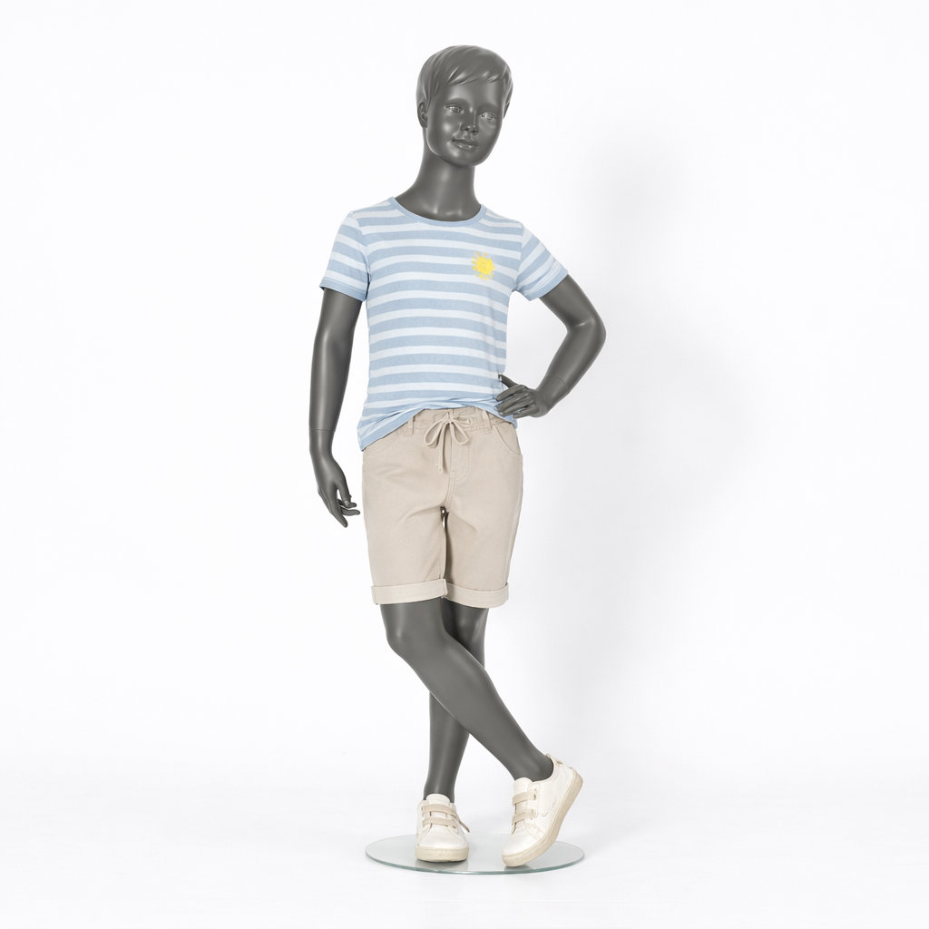 Mannequin enfant, main sur la hanche et jambes croisées